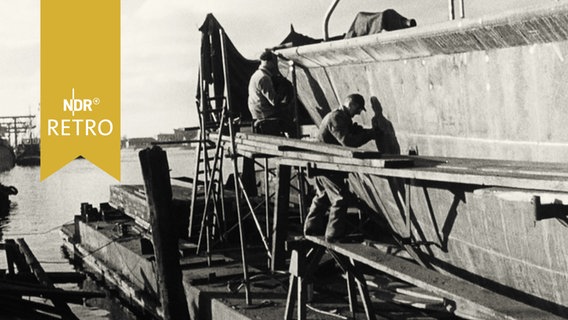 Arbeiter in einer Werft in Wilhelmshaven 1959 bein Anstrich eines Schiffs  