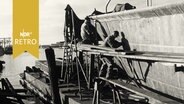 Arbeiter in einer Werft in Wilhelmshaven 1959 bein Anstrich eines Schiffs  