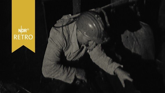Angeseilter Grubenretter steigt in einen Rettungsschacht in Lengede (1963)  