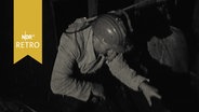 Angeseilter Grubenretter steigt in einen Rettungsschacht in Lengede (1963)  