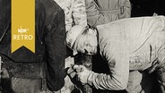 Helfer an der Grube Mathilde lauscht an einem Rohr, was die unter Tage eingeschlossenen Kumpel ihm mitteilen (November 1963)  