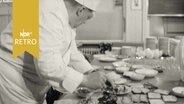Hobbykoch mit Kochmütze bei der Zubereitung eines Buffets 1961  
