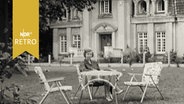 Frau sitzt am Kaffeetisch im Garten einer Villa (1965)  