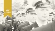 Polizeibeamte marschieren in Reih und Glied (1964)  