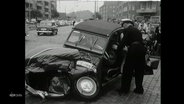 Archivmaterial aus den 60er-Jahren zeigt ein verbeultes Fahrzeug nach einem Unfall.  