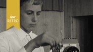 Ein Schüler setzt ein Dia in einen Projektor  (1965)  