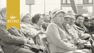 Zahlreiche meist ältere Frauen in Mänteln sitzen in einer Veranstaltung der evangelischen Landeskirche Hannover (1961)  