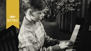 Junge am Klavier bei einer Aufführung (1961)  
