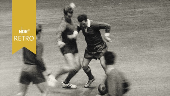 Hallenfußball-Spielszene 1965 mit einem Spieler des SV Werder Bremen gegen drei Gegner  