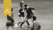 Hallenfußball-Spielszene 1965 mit einem Spieler des SV Werder Bremen gegen drei Gegner  