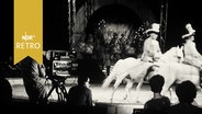 Reiter auf Schimmeln in einer Zirkusmanege vor einer Kamera (1965)  