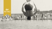 Springer in vortrefflicher Haltung beim Rückwärtssalto vom 1-Meter-Brett im Freibad (1961)  