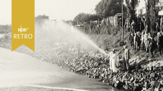 Feuerwehrleute spritzen Ölabsorptionsmittel in die Weser (1965)  