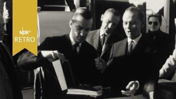 HHLA-Vorsitzender Ernst Plate sichtlich überrascht, als ihm Pressefotografen die "Goldene Blende" überreichen (1965)  