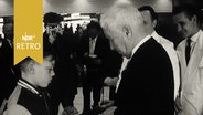 Charlie Chaplin gibt einem Jungen ein Autogramm auf dem Flughafen Hamburg-Fuhlsbüttel (1961)  