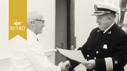 Kapitän der "Bremen" schüttelt Steward Siegbert Grund die Hand zu seiner Verabschiedung nach 25 Dienstjahren (1961)  