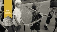 Kind mit einem Fischernetz (Kescher) auf dem Festumzug zu 150 Jahre Haffkrug (1961)  