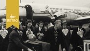 Passagiere aus Kopenhagen am Bremer Flughafen während des Freimarktes 1961 mit Lebkuchenherzen dekoriert  