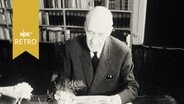 Autor Walther von Hollander 1962 an seinem Schreibtisch mit einem Stapel Post  