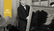 Helfer tragen bei einer Auktion 1962 ein Gemälde weg  