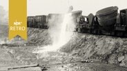 Glühende Schlacke wird von einem Güterzugwaggon in die Schlackegrube gekippt (1962, Stahlhütte Salzgitter)  