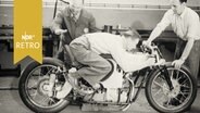 Wilhelm Herz demonstriert auf einer stehenden NSU die aerodynamischste Haltung des Motorradfahrers. (1962)  