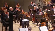 Paavo Järvi dirigiert ein Orchester im Großen Saal der Elbphilharmonie.  