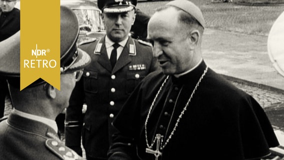 Offizier begrüßt einen katholischen Geistlichen bei dessen Besuch der Führungsakademie der Bundeswehr 1965  