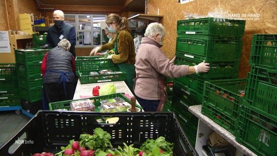 Menschen ordnen Kisten mit Lebensmitteln.  