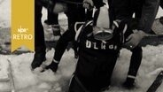 Einem Eistaucher der DLRG wird aus einem Eisloch geholfen (1963)  