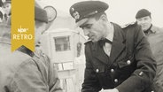 Offizier der Bundesmarine überreicht Seeleuten auf der Nordsee ein Weihnachtsgeschenk (1964)  