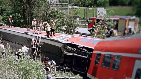 Rettungskräfte arbeiten an einem entgleisten Zug. © SWR/BR24 