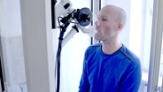 Autor Nils Casjens hat ein Atemlufttestgerät im Mund. © NDR 