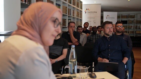 Kollegiaten des Islamkolleg Osnabrück sitzen vor einer Dozentin. © NDR 