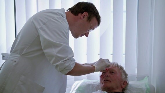 Ein junger Arzt behandelt einen Mann © NDR 
