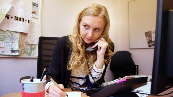 Lokaljournalistin Anna Petersen an ihrem Schreibtisch bei der Telefonrecherche. © JABFilm/NDR 