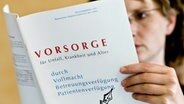 Eine Frau liest in einem Informations-Heft über Vorsorge für Unfall, Krankheit und Alter durch Vollmacht, Betreuungs- und Patientenverfügung, © dpa-Report 