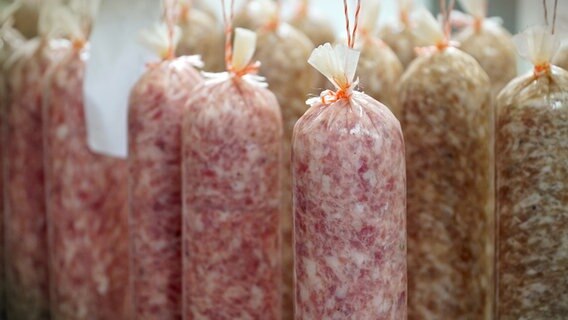 Mehrere senkrecht hängende Salamis in verschiedenen Reifezuständen. © NDR/e-dok TV/Julian Prahl 