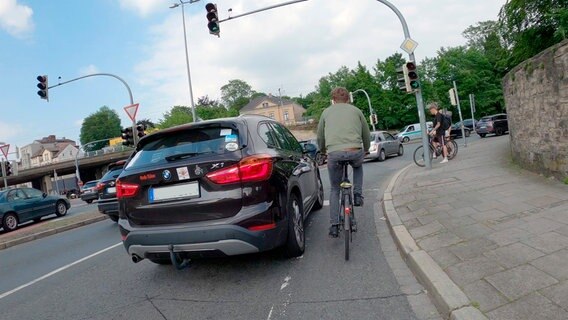 Beim Überholen müssen Autofahrer*innen innerorts mindestens 1,5 Meter Seitenabstand zu Radfahrenden einhalten. Doch auf schmalen Radstreifen, wie hier am Osnabrücker Wallring, kommt es zu gefährlich engen Überholmanövern. © NDR/Güven Purtul 