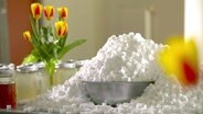 Tisch mit Tulpenvasen und einem riesigen Berg von Würfelzucker, der über eine Schüssel quillt. © NDR/45Min 