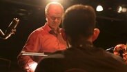 Ein Dirigent schaut auf einen Musiker vor ihm. © NDR/7Tage 