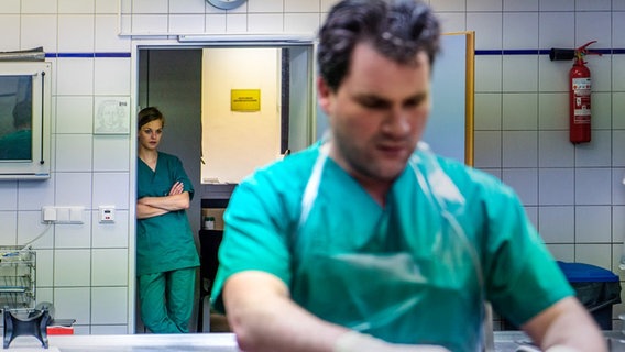 Zwei Menschen im Kittel in einem Obduktionssaal der Gerichtsmedizin. © © NDR 