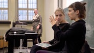 Zwei Frauen in einem Hörsaal. Eine von ihnen gebärdet. © NDR/Lisa Wolff/Henning Wirtz 