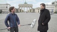 Ein Reporter steht mit Lars Klingbeil vor dem Brandenburger Tor. © NDR/7 Tage 