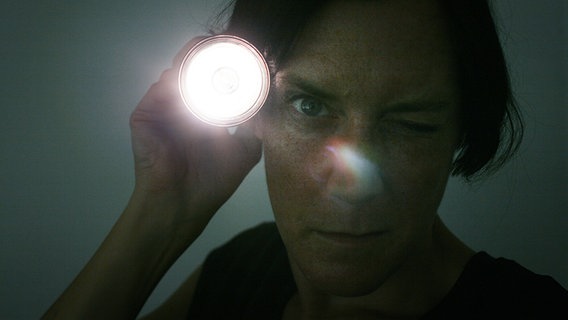 Eine Frau strahlt mit einer Taschenlampe © photocase.de Foto: inkje