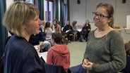 Zwei Frauen in einem Seminarraum im Gespräch. © NDR/7Tage 