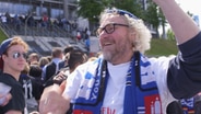 Ein fröhlicher Mann mit HSV-Schal und -Mütze. © NDR/7Tage 