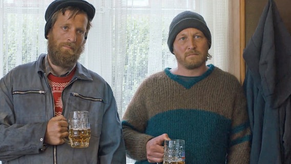 Szenenbild aus der sechsteiligen Komödie "Da is' ja nix": Zwei Männer (Hannes & Andreas Köhler) stehen am Fenster. © NDR 