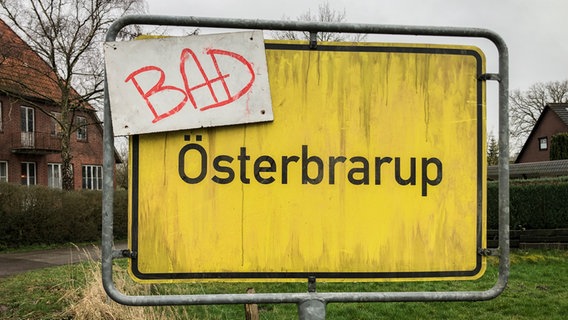 Das Ortsschild "Österbrarup" wurde mit einem nachträglichen Hinweis "Bad" versehen.. © NDR/Georges Pauly Foto: Georges Pauly