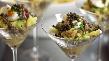 Kartoffelsalat mit Linsen und frittierten Kapern in einem Cocktailglas serviert. © NDR 